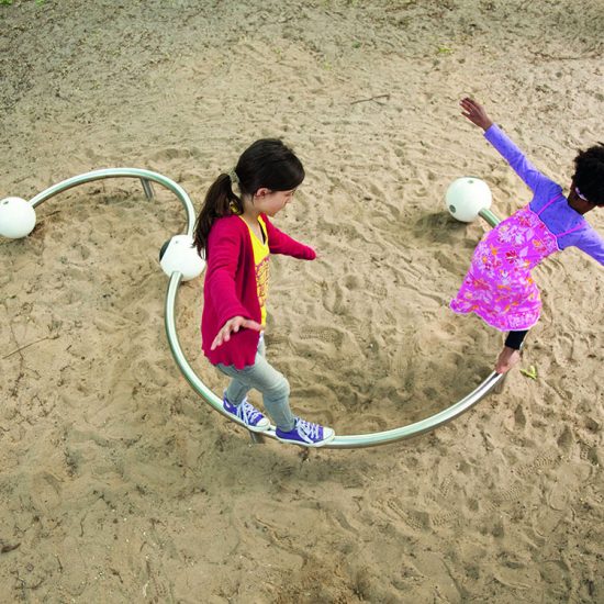 Girls playing on curved balance beam