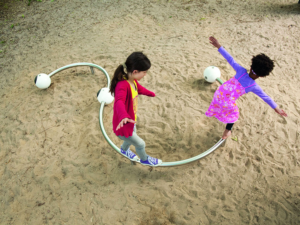 Girls playing on curved balance beam