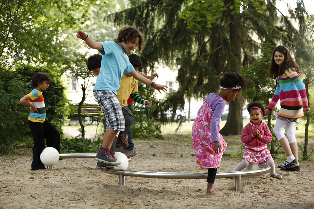 Children playing on Orbit curved balance beam