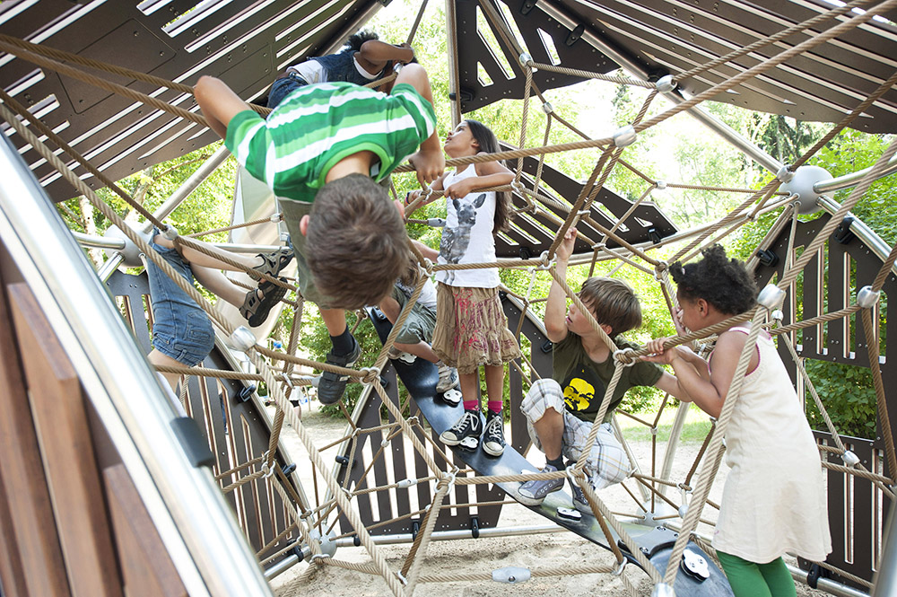 Children inside bamboo climbing unit on rope net