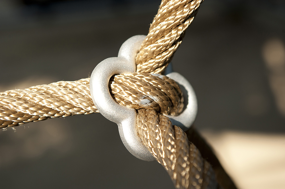 Cloverleaf ring holding two beige ropes