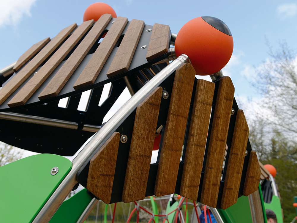 Bamboo panel of toddler play unit with orange ball joint