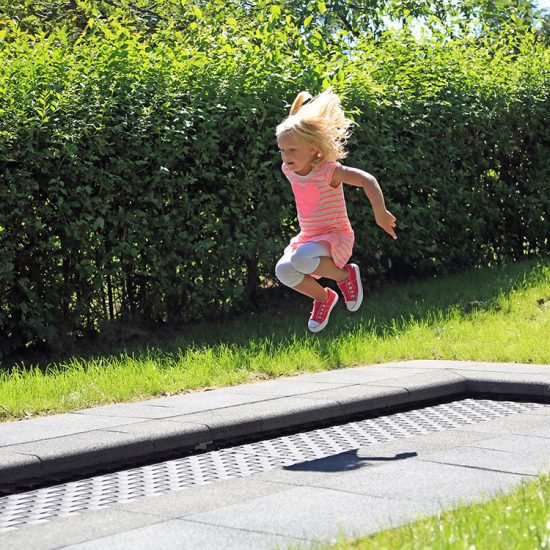 Girl playing on kids tramp track trampoline