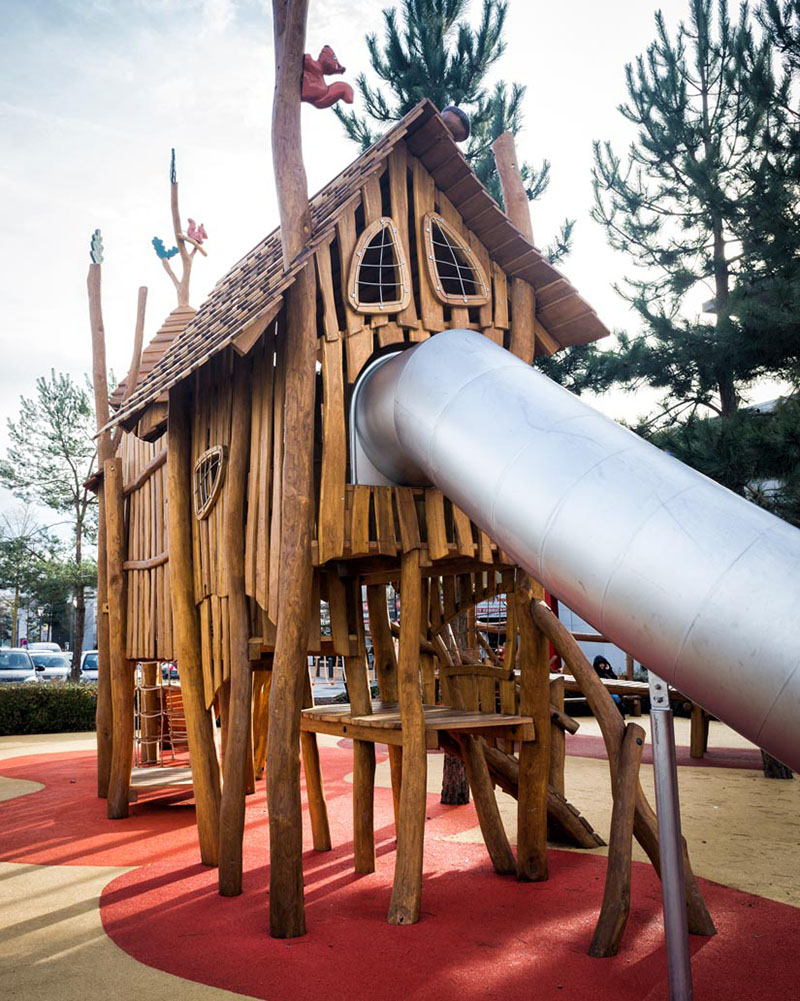 Front view of timber climbing structure with tube slide