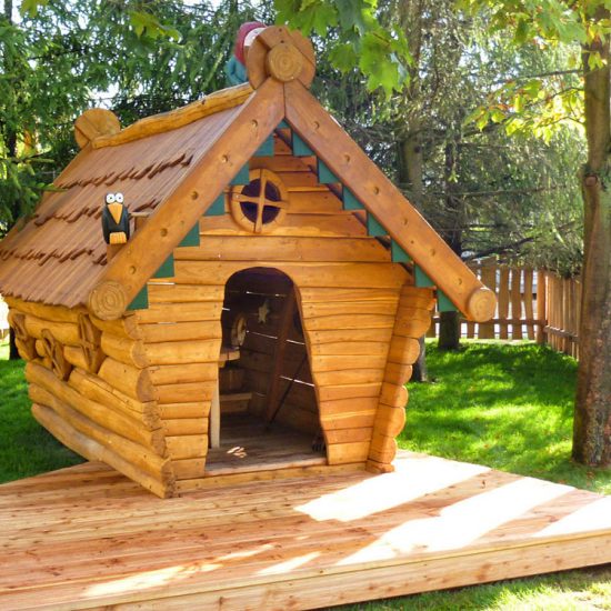 Wooden cabin themed playhouse with raven sculpture