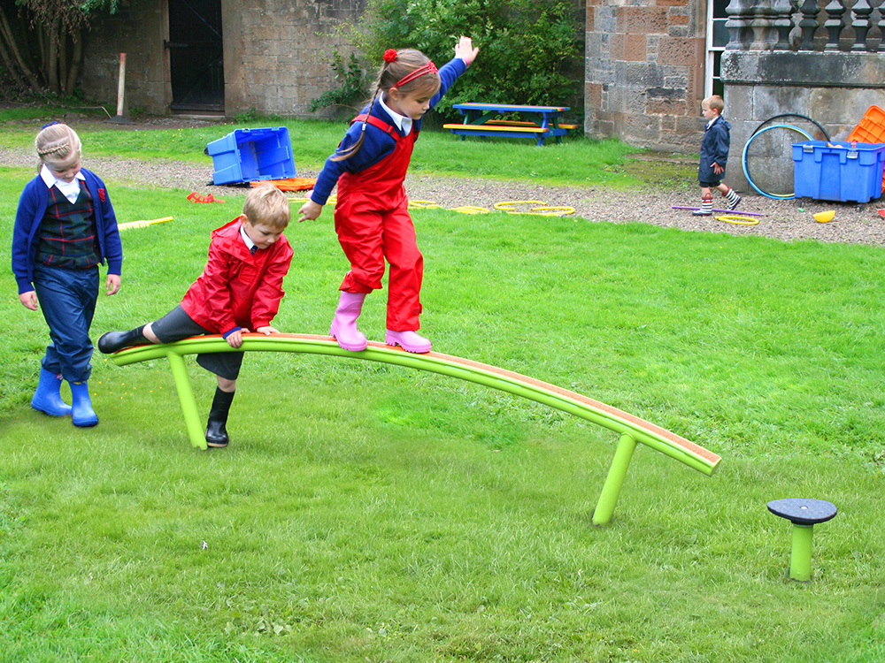Children on balance beam in school playground