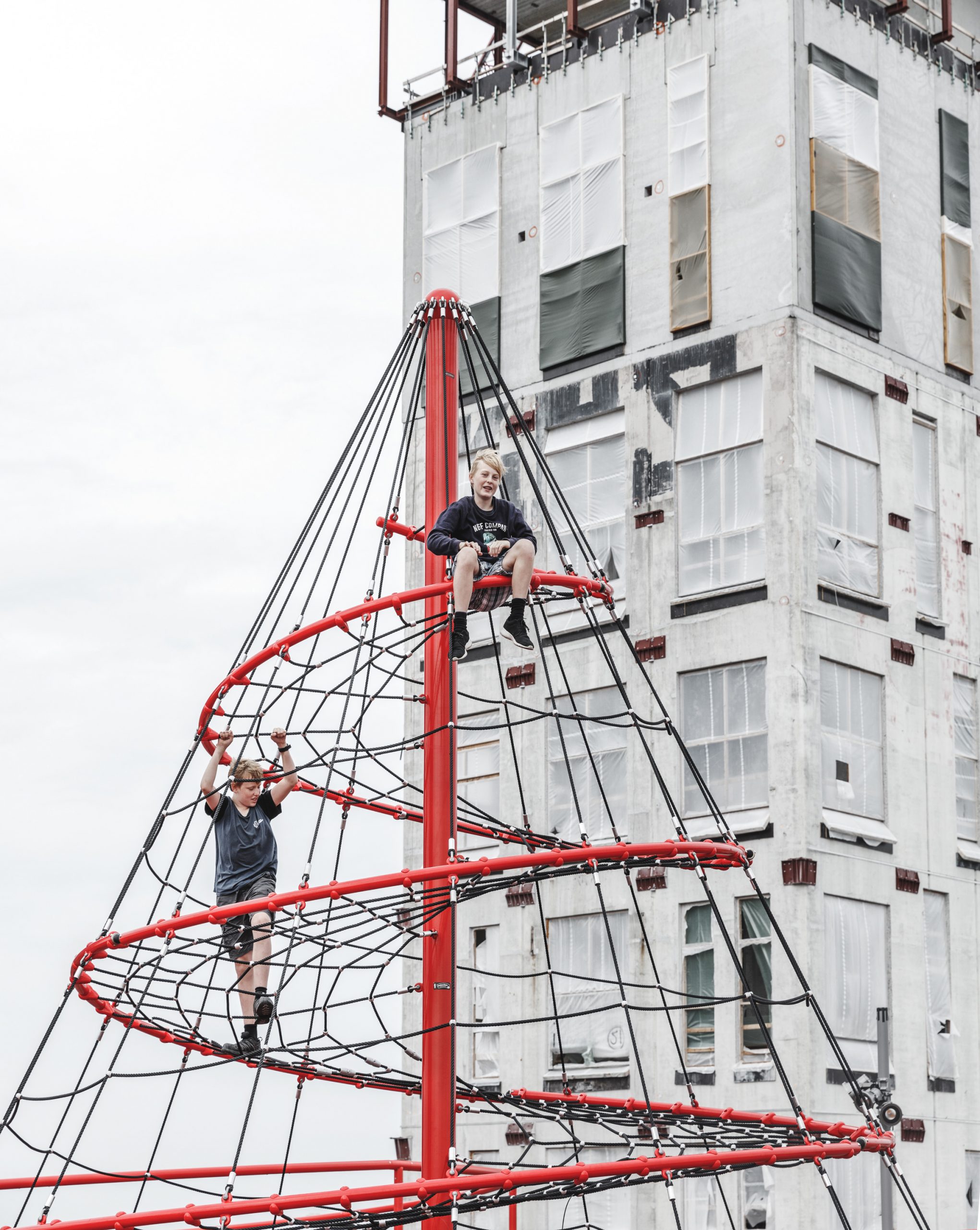 Children on helical pyramid climber on rooftop playground